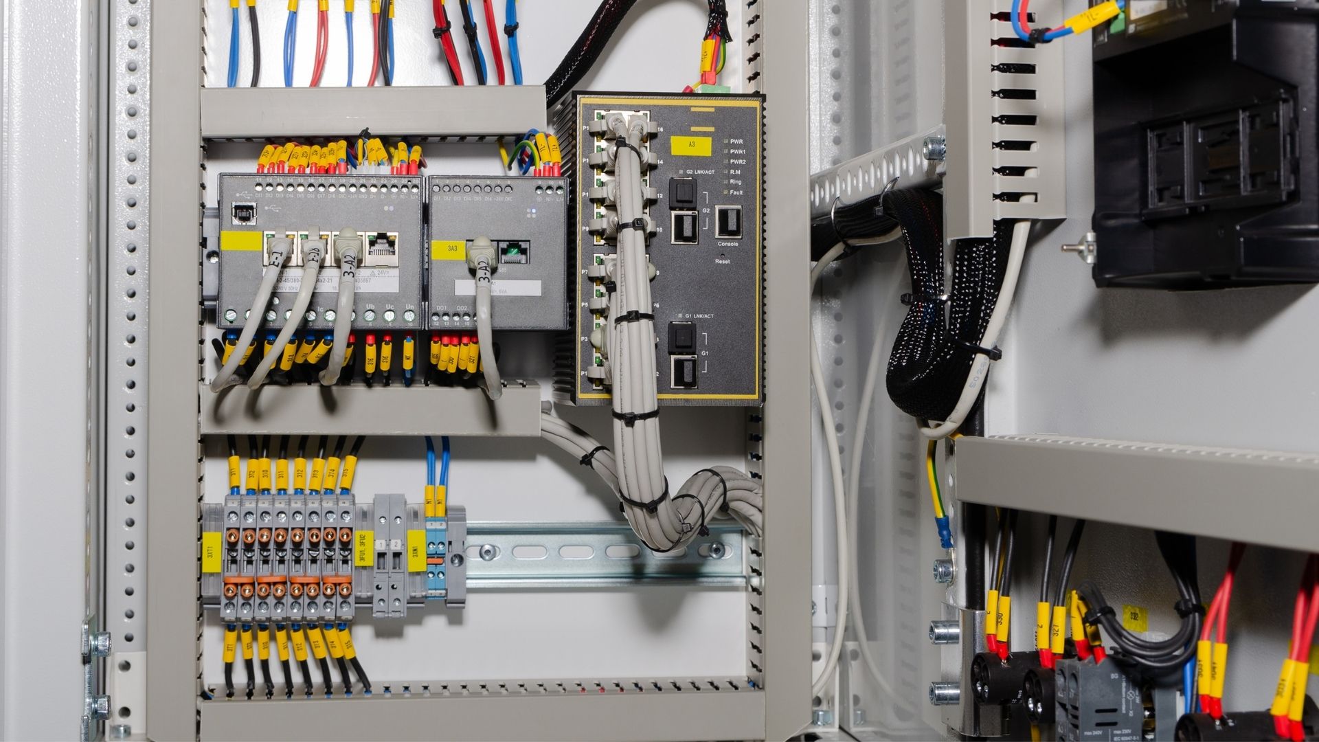 Detail komponen kontrol industri dan wiring rapi dalam proses perakitan panel kontrol presisi tinggi menggunakan standar desain EPLAN oleh ICI Automation.